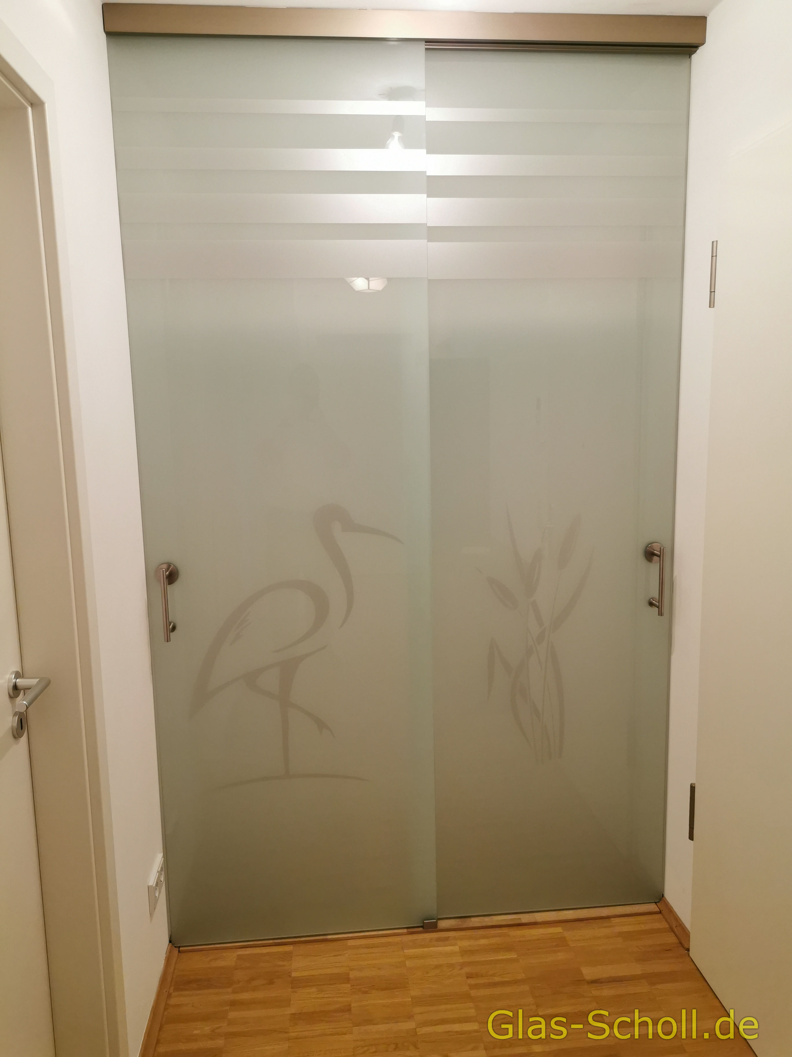 Zweiflüglige Schiebetür vor einer Garderobe mit Motiv von Glas Scholl